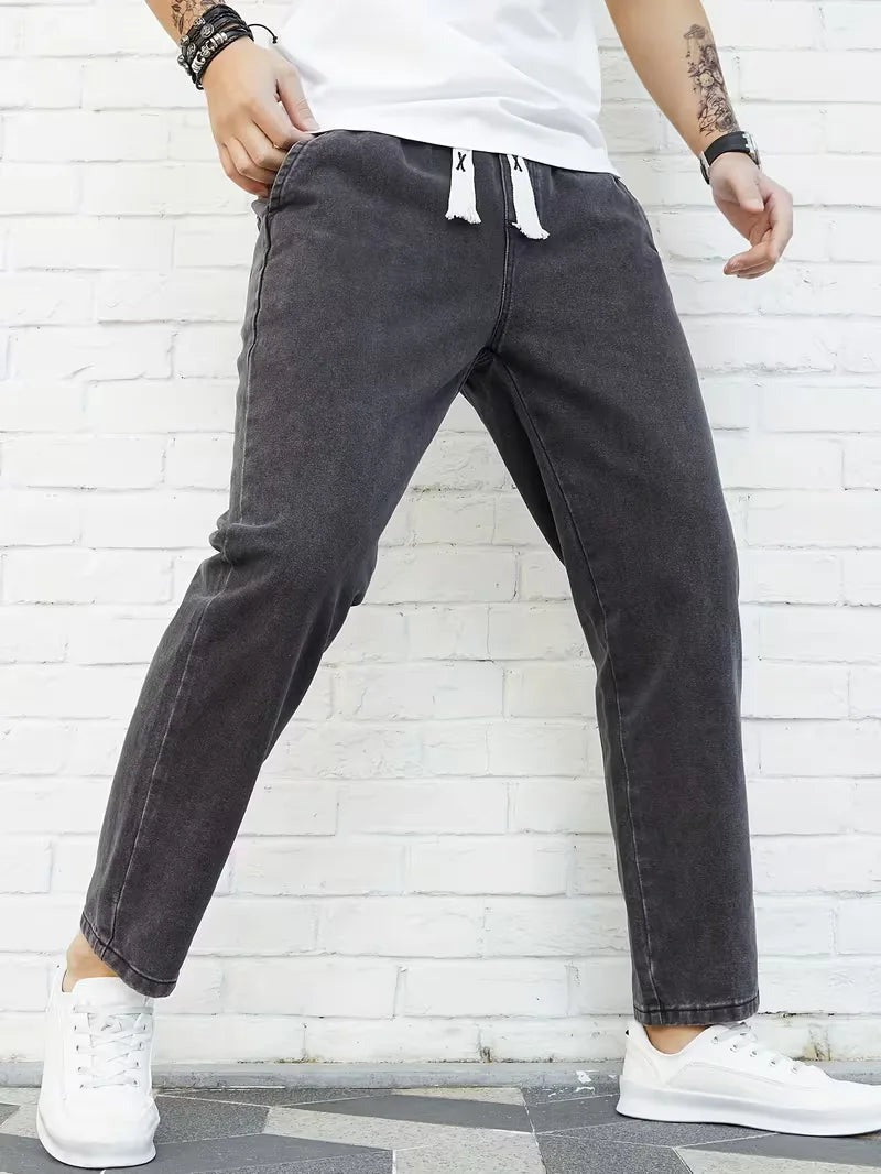 Joggerjeans voor heren in donkergrijs met trekkoord, gedragen, voorkant