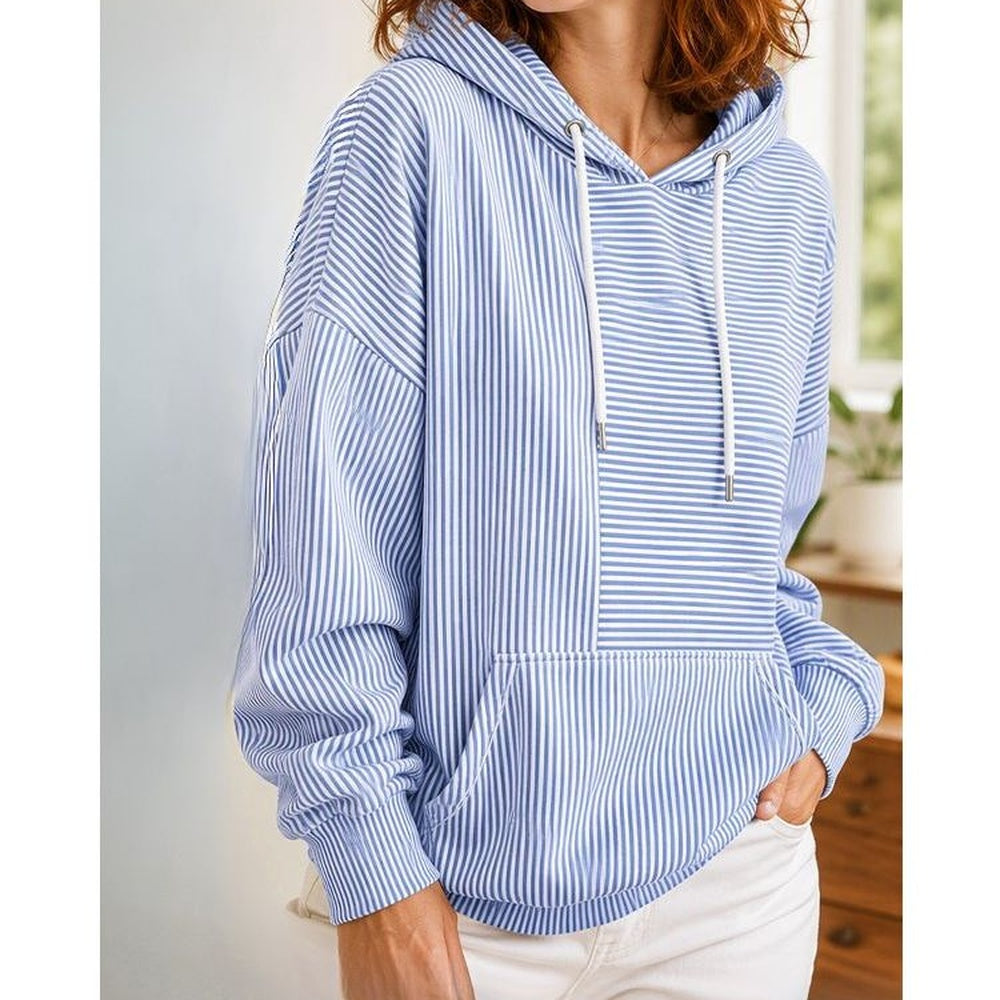 Vrouw in lichtblauwe gestreepte trui met een witte broek, binnen in een lichte kamer | Boutique Moda