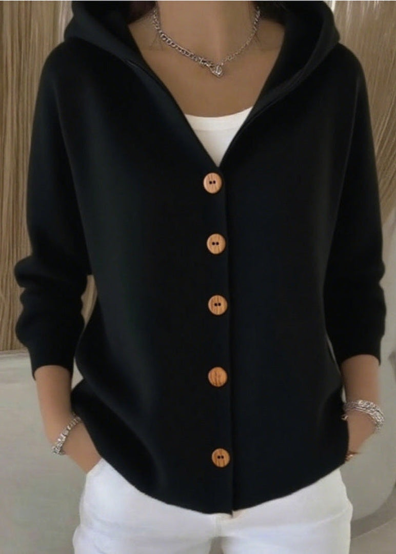 Zwart capuchonvest met knoopsluiting, gedragen door vrouw met witte broek | Boutique Moda