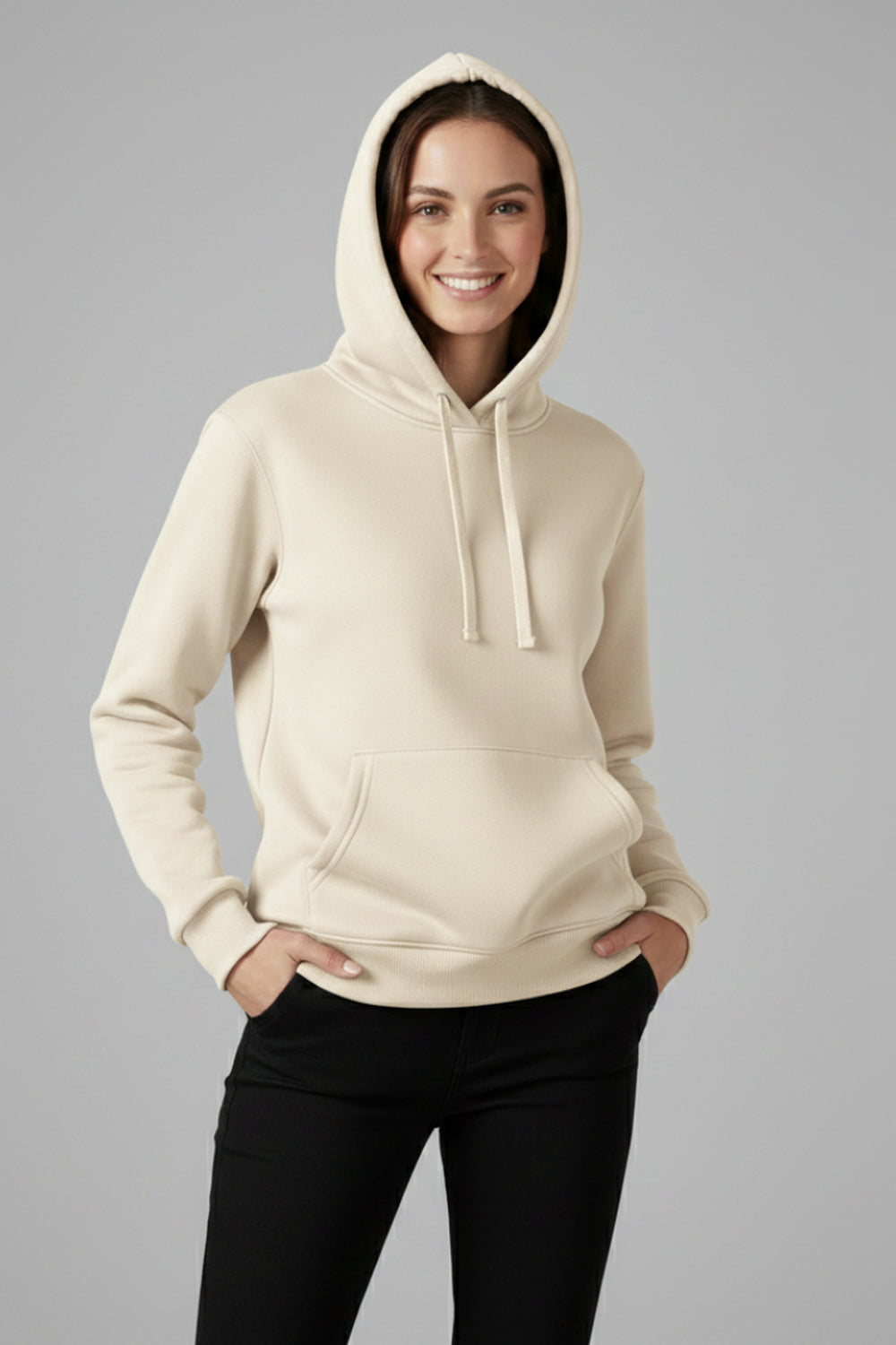 Vrouw in een crèmekleurige basic hoodie met koorden, handen in de broekzakken | Boutique Moda