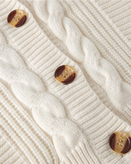 Knoopsluiting van het crèmekleurige kabelvest, close-up