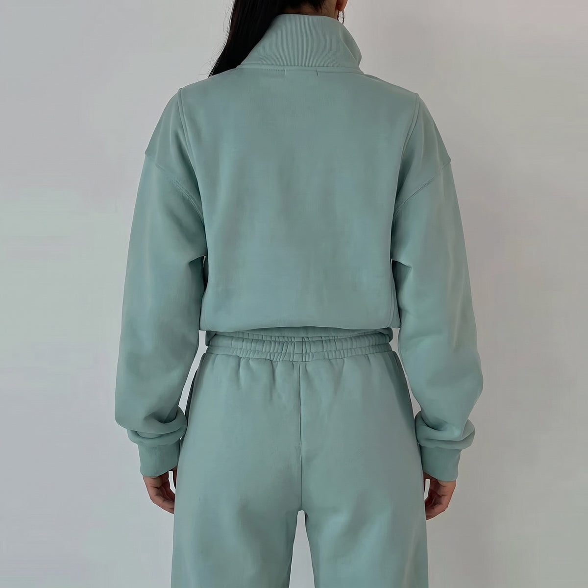 Mintgroen half-zip sweatshirt met joggingbroek, gedragen door vrouw van achteren | Boutique Moda