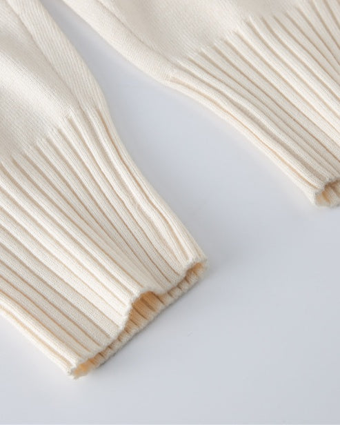 Geribde enkelboorden van de crèmekleurige gebreide broek, close-up