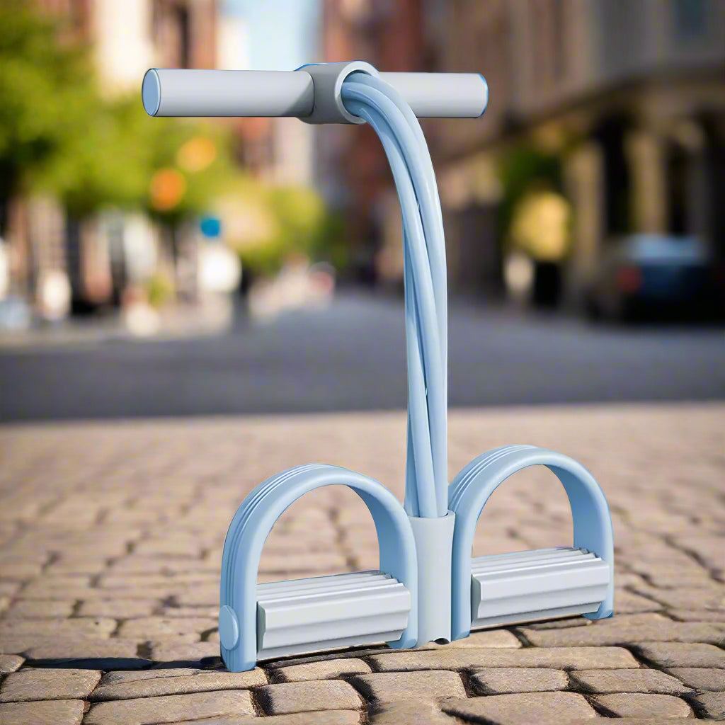 Lichtblauwe weerstandsband met voetpedalen en handgreep, vrijstaand op straat | Boutique Moda