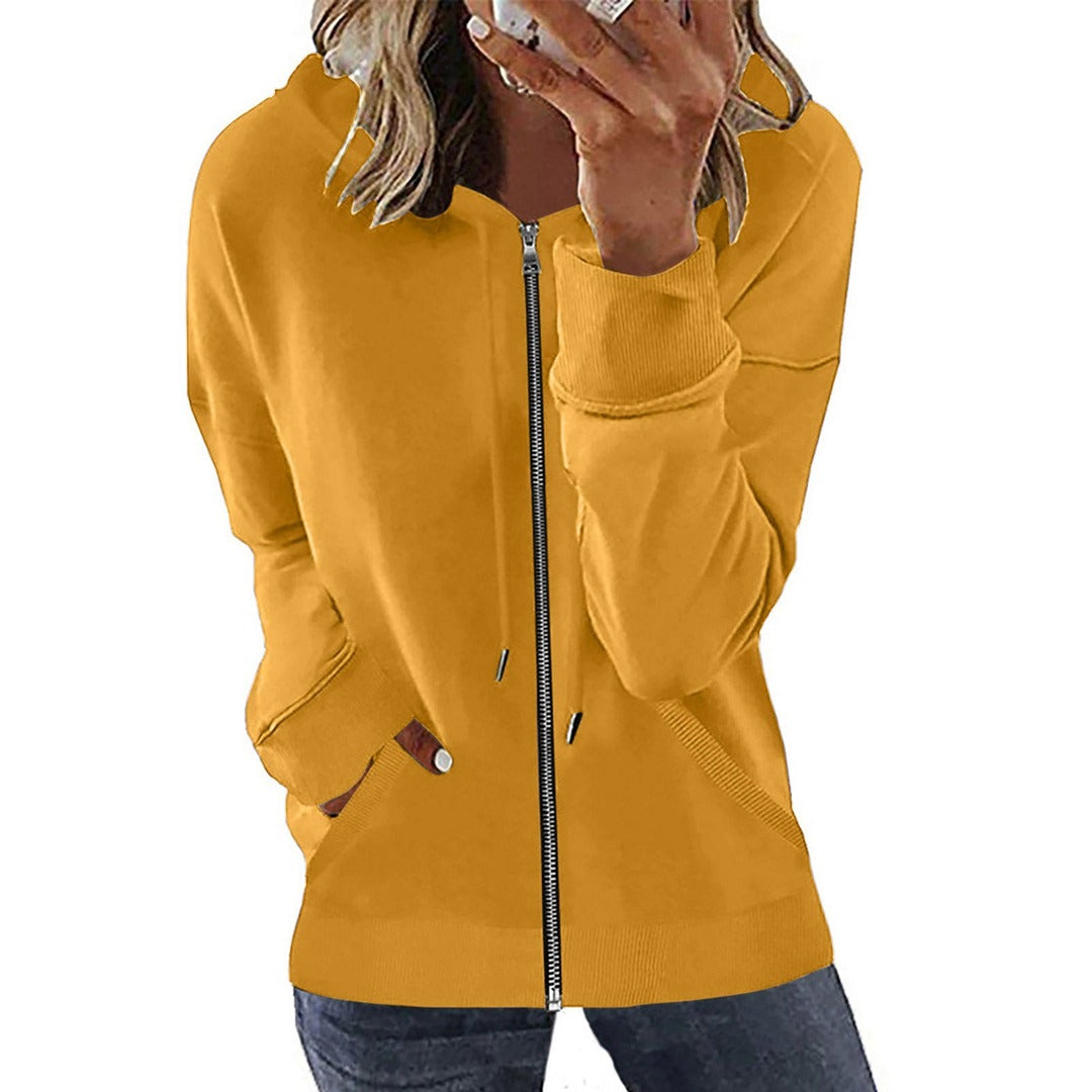 Vrouw in een mosterdgeel sweatvest met metalen rits, hand bij het gezicht | Boutique Moda