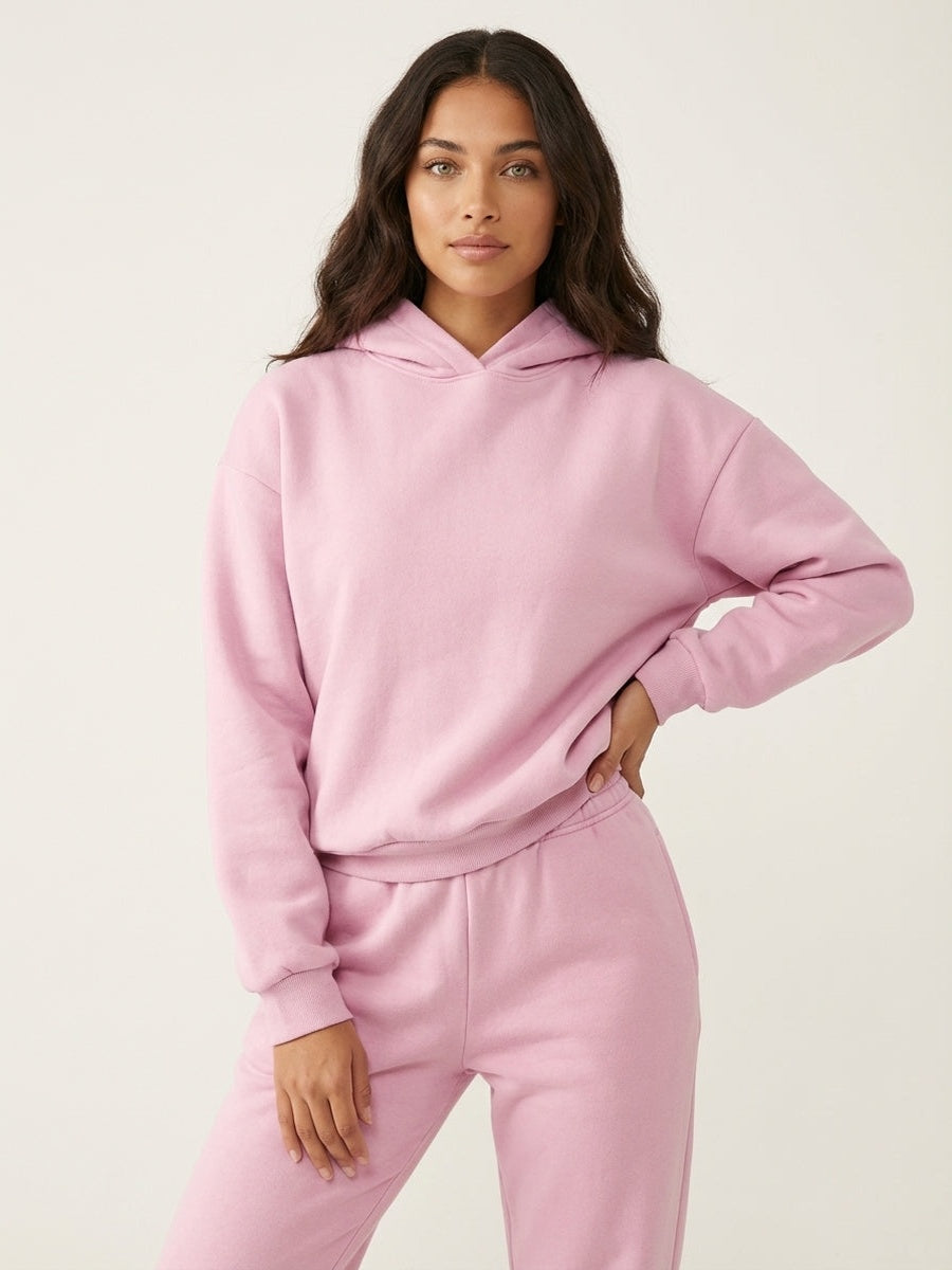 Oversized hoodie en joggingbroek in roze, hand op de heup