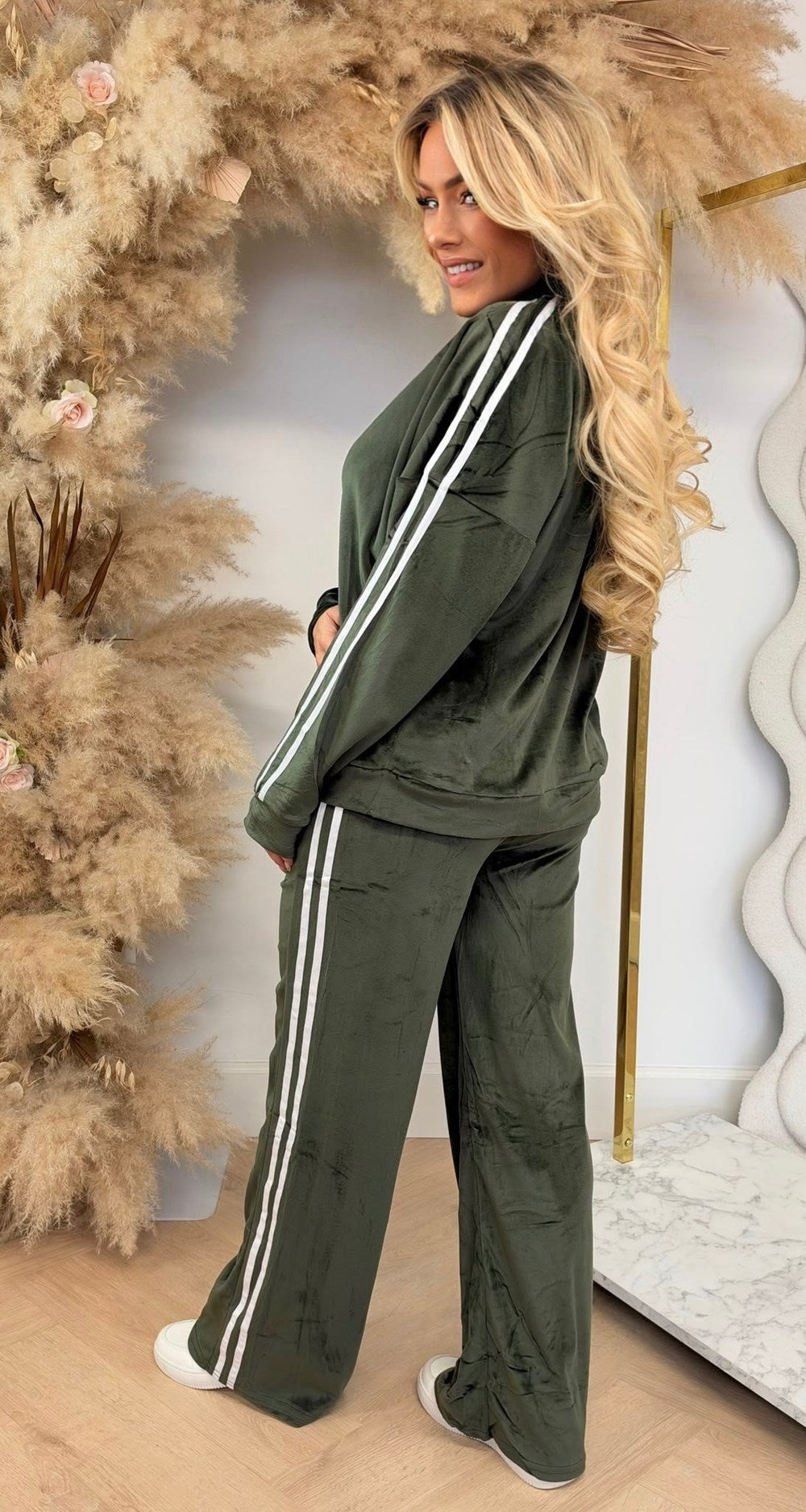 Velours joggingpak in legergroen met witte zijstrepen, vest met rits en rechte broek, zijaanzicht