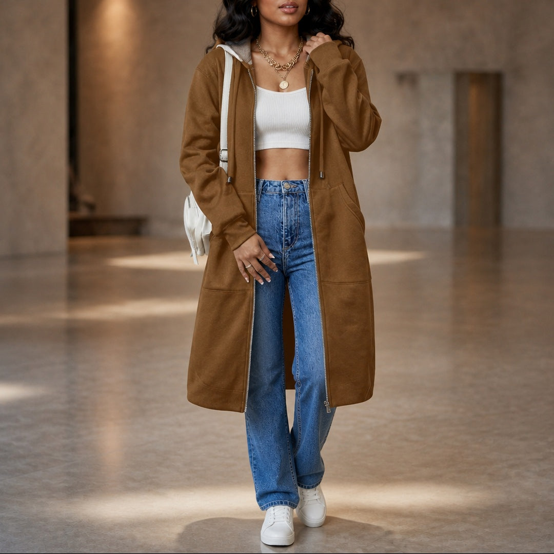Vrouw in een lang karamelkleurig vest met een witte tas over de schouder | Boutique Moda