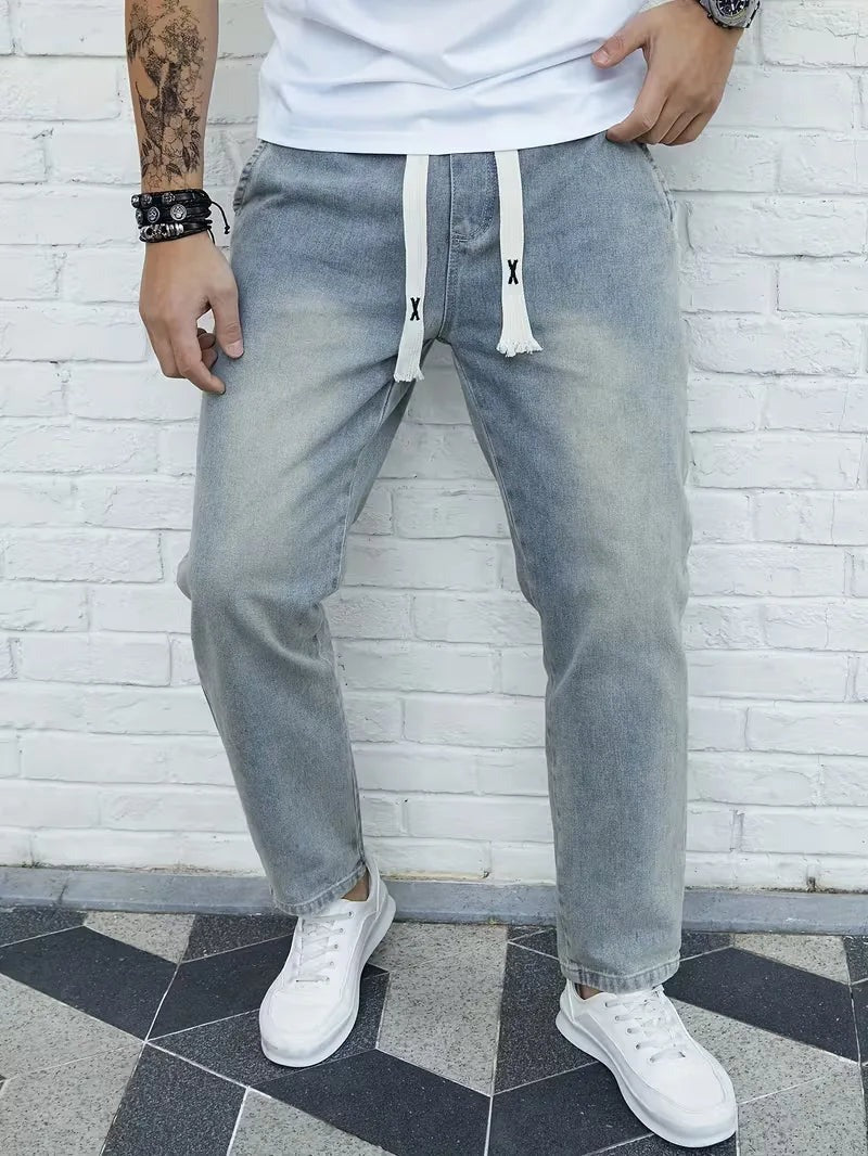 Joggerjeans voor heren in vintageblauw met trekkoord, gedragen, voorkant