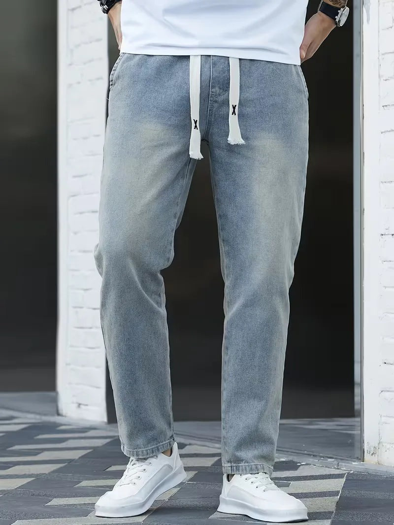 Joggerjeans voor heren in vintageblauw met trekkoord, gedragen, voorkant