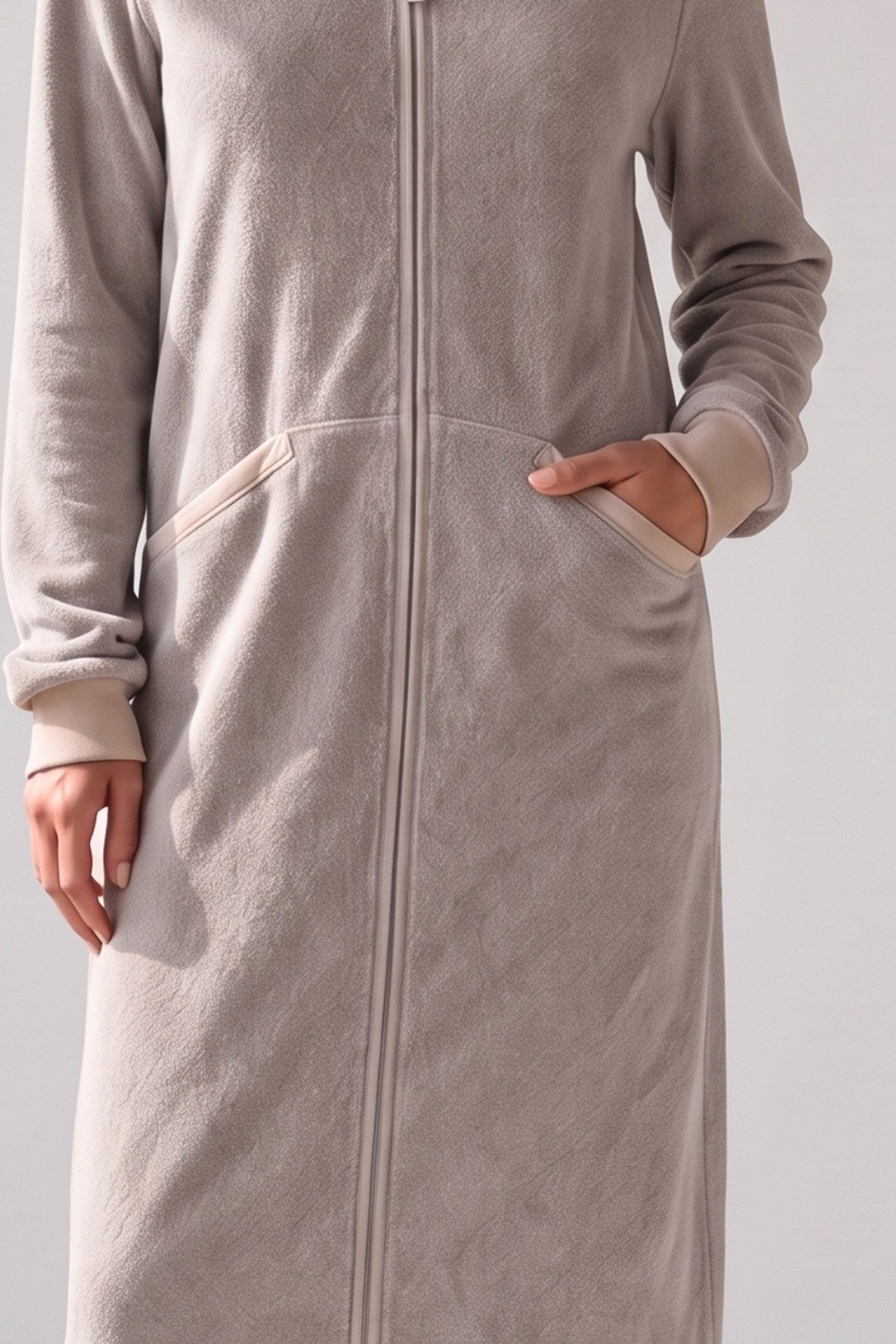 Zachte taupe pluchefleece met lichte biezen langs de zakken, stofdetail