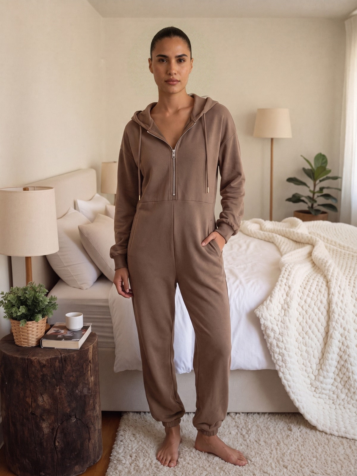 Onesie met capuchon in mokka aan een model, vooraanzicht in de slaapkamer