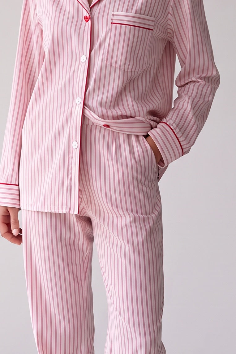 Lichtroze katoenen pyjama met dunne rode streepjes en rode biezen, stofdetail