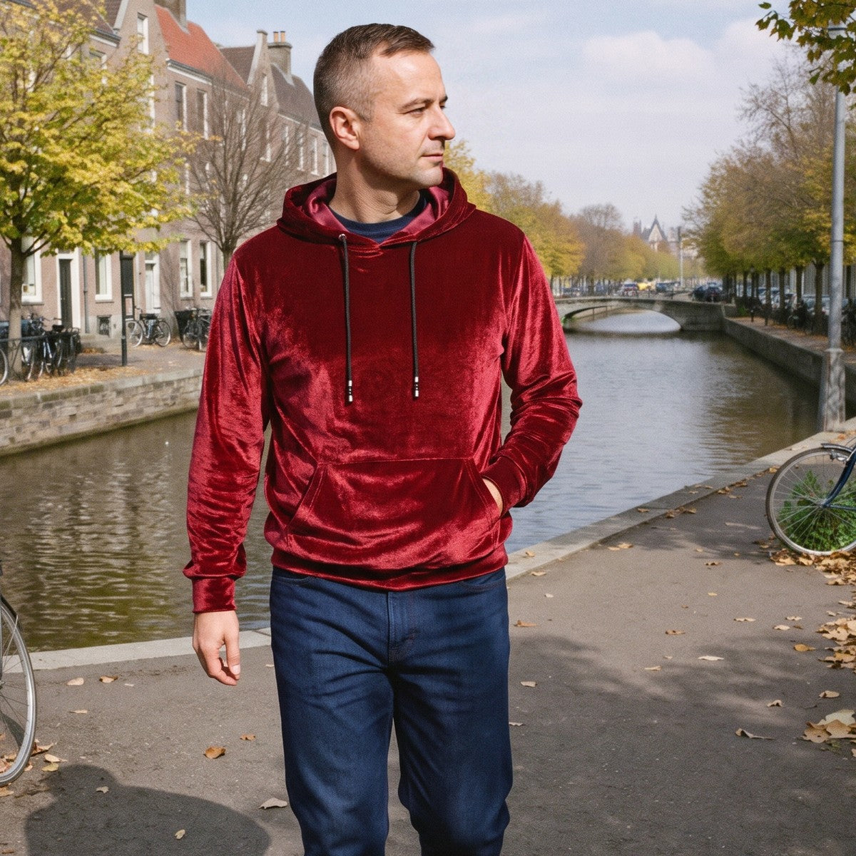 Fluwelen hoodie voor heren in rood, gedragen door een model op straat