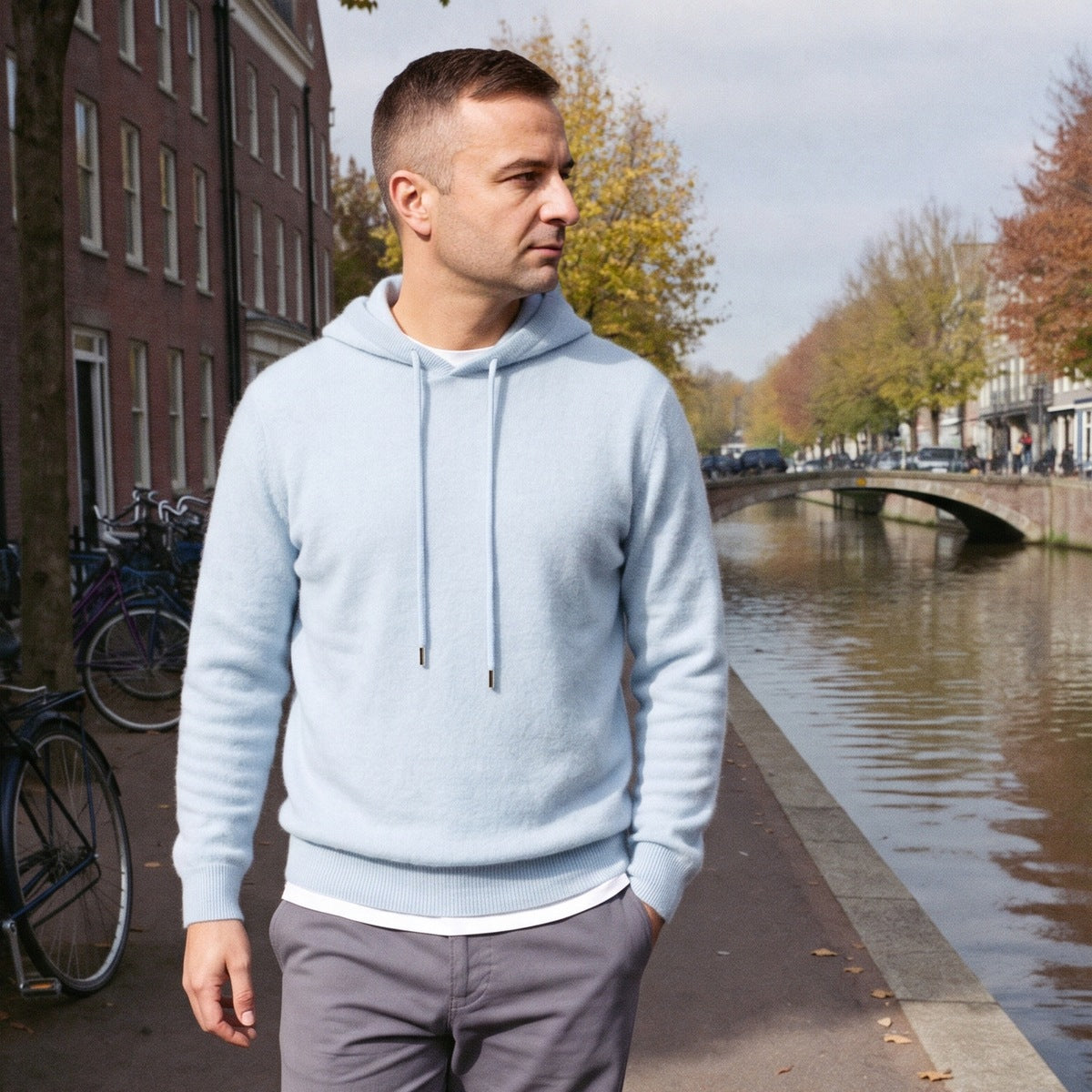 Lichte gebreide hoodie voor heren in lichtblauw, gedragen door een model op straat