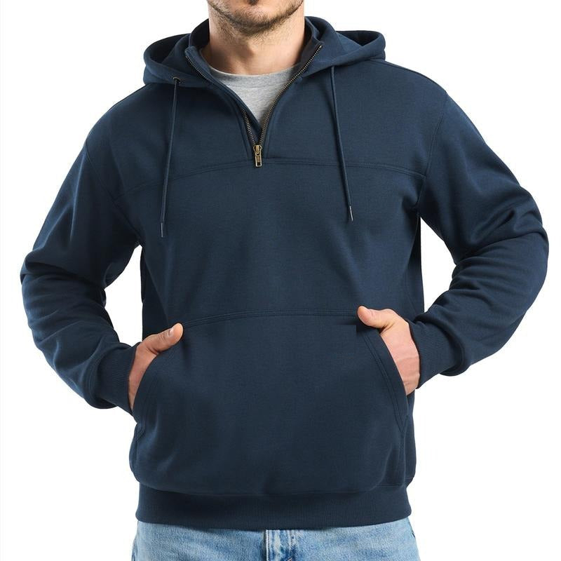 A man wears a navy blue quarter-zip hooded sweatshirt with his hands in the front pocket.