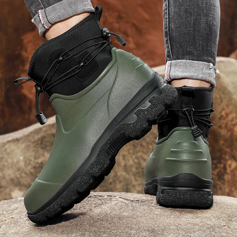 Groene met zwarte regenlaarzen met veters, gedragen door persoon op rots | Boutique Moda