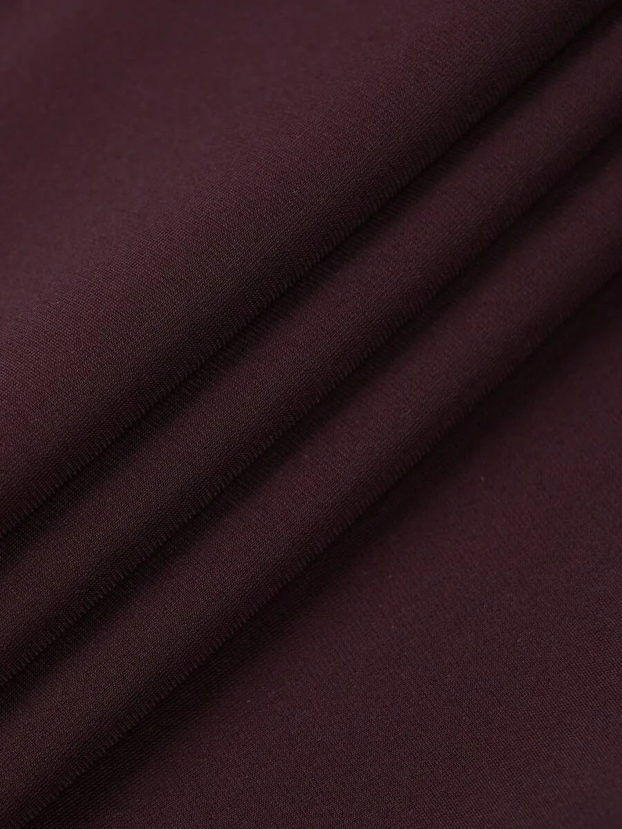 Close up macro shot of folded dark burgundy fabric with visible texture.
