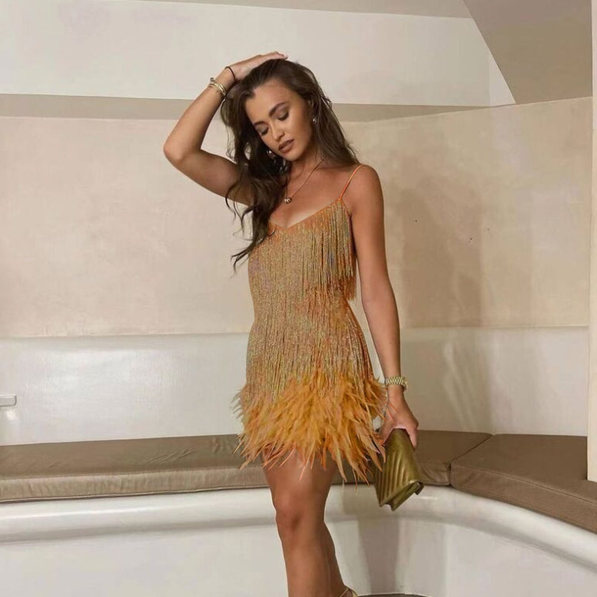 Gouden kwastjesjurk met veren zoom, gedragen door vrouw met hakken | Boutique Moda