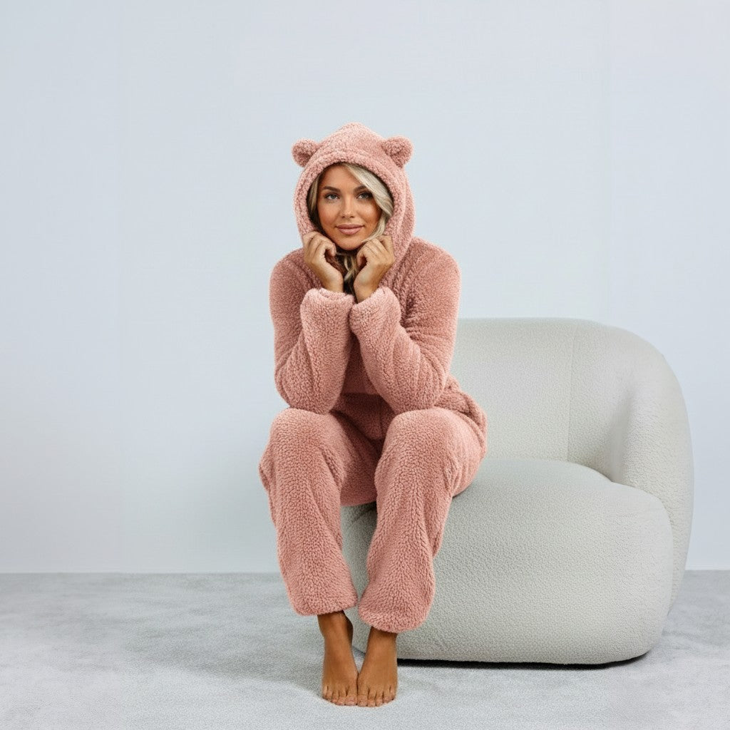 Roze fleece onesie met beertjes-capuchon, gedragen door zittende vrouw | Boutique Moda