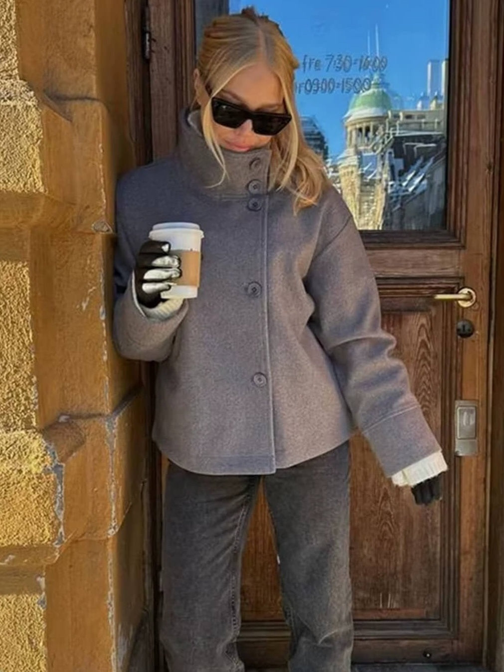 Grijze oversized jas met hoge kraag, gedragen door vrouw buiten | Boutique Moda
