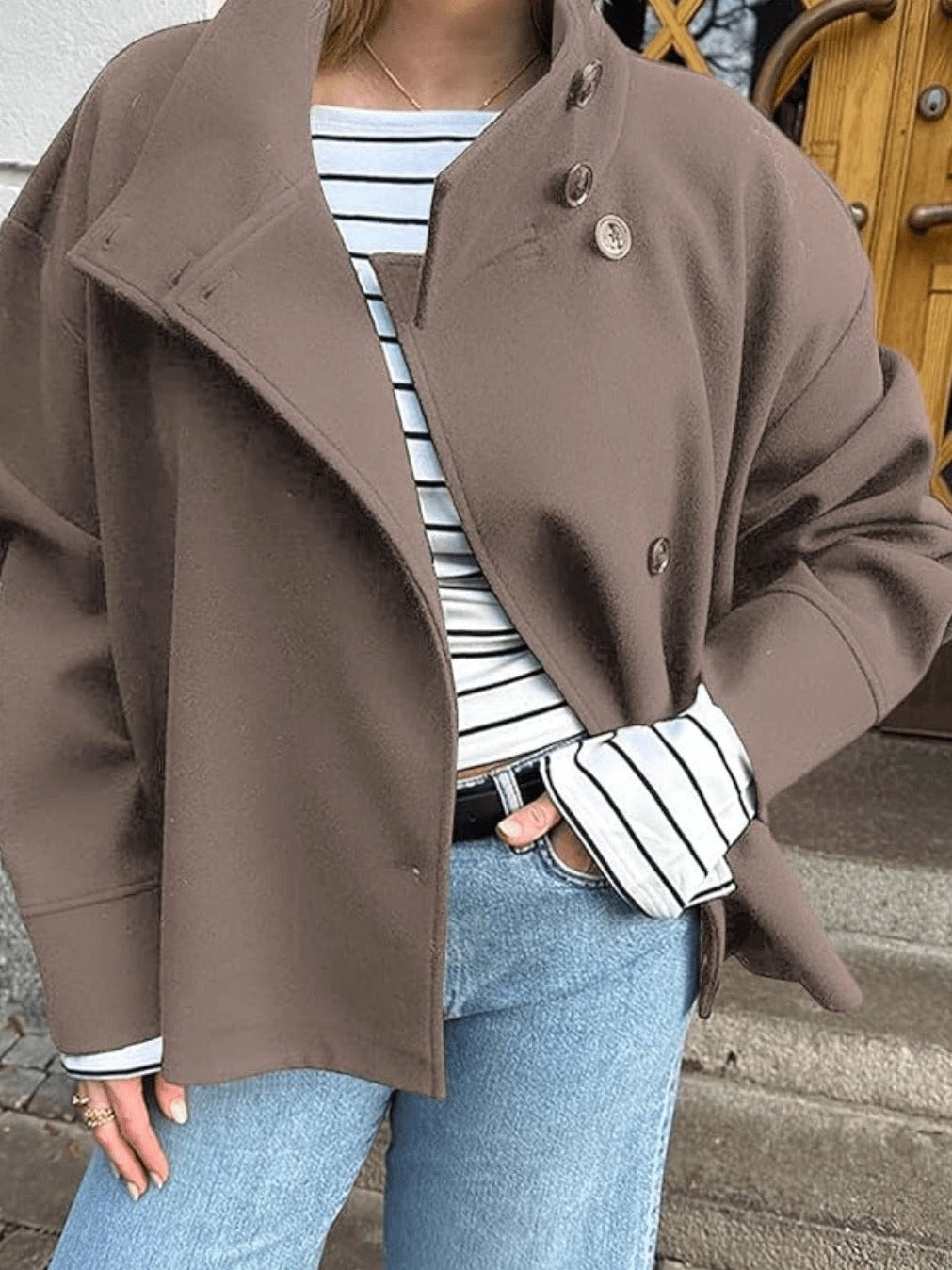 Bruine oversized jas met opstaande kraag, gedragen over gestreepte blouse | Boutique Moda