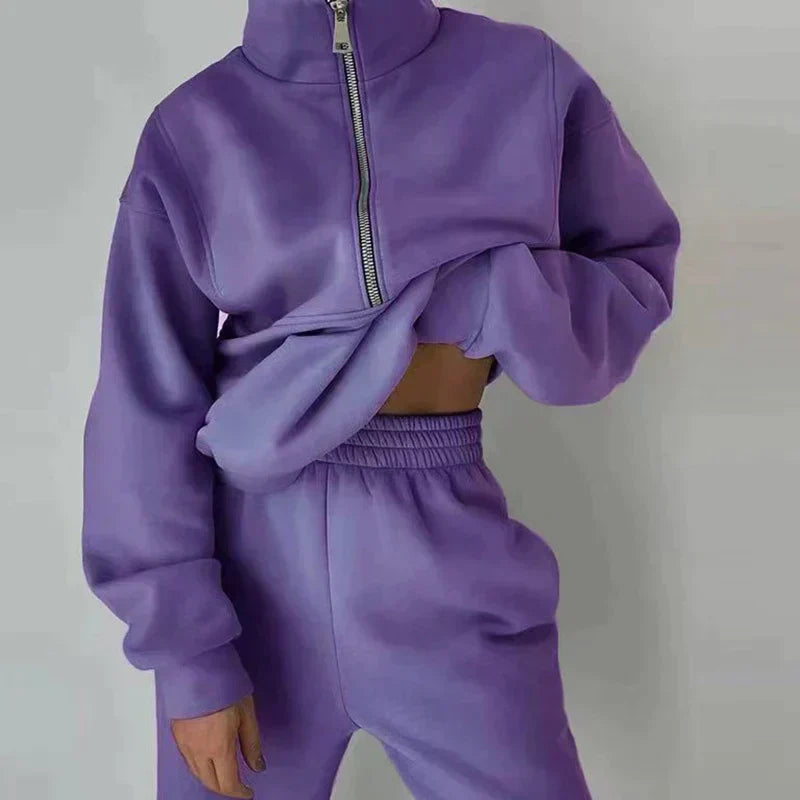 Paarse joggingset met halve rits, gedragen door een vrouw, gekropte sweater | Boutique Moda