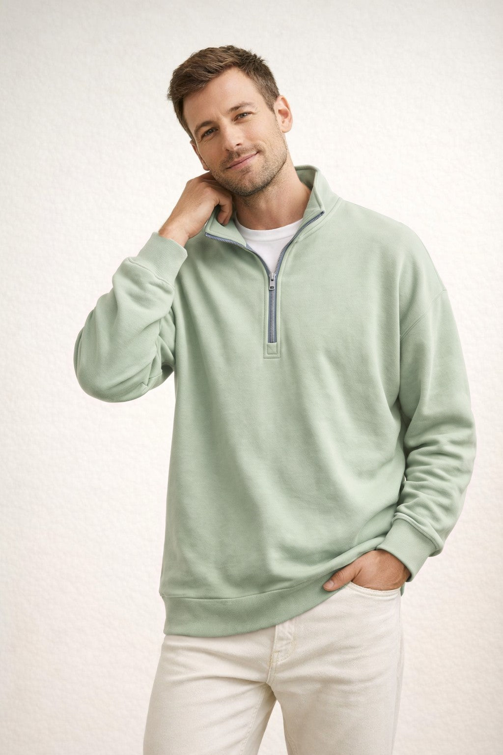 Man draagt groene sweater met halve rits en witte broek | Boutique Moda