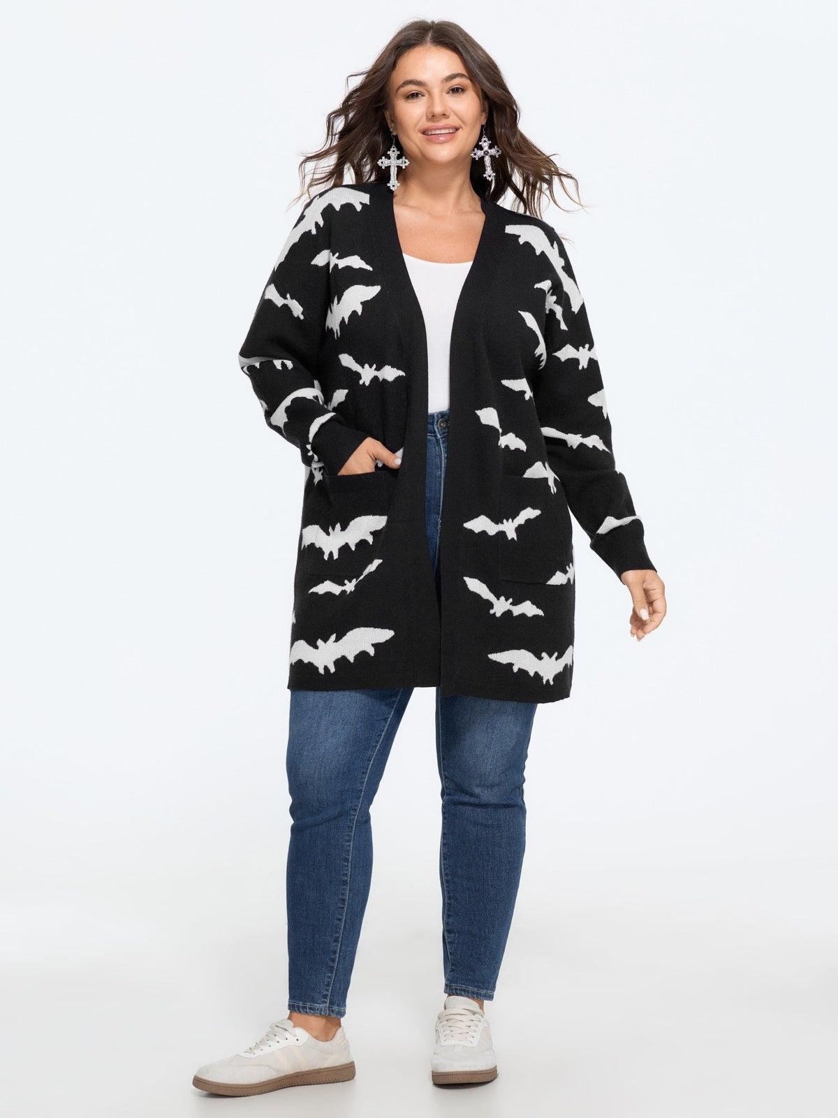 Vrouw in het vleermuis vest met jeans, volledige lengte