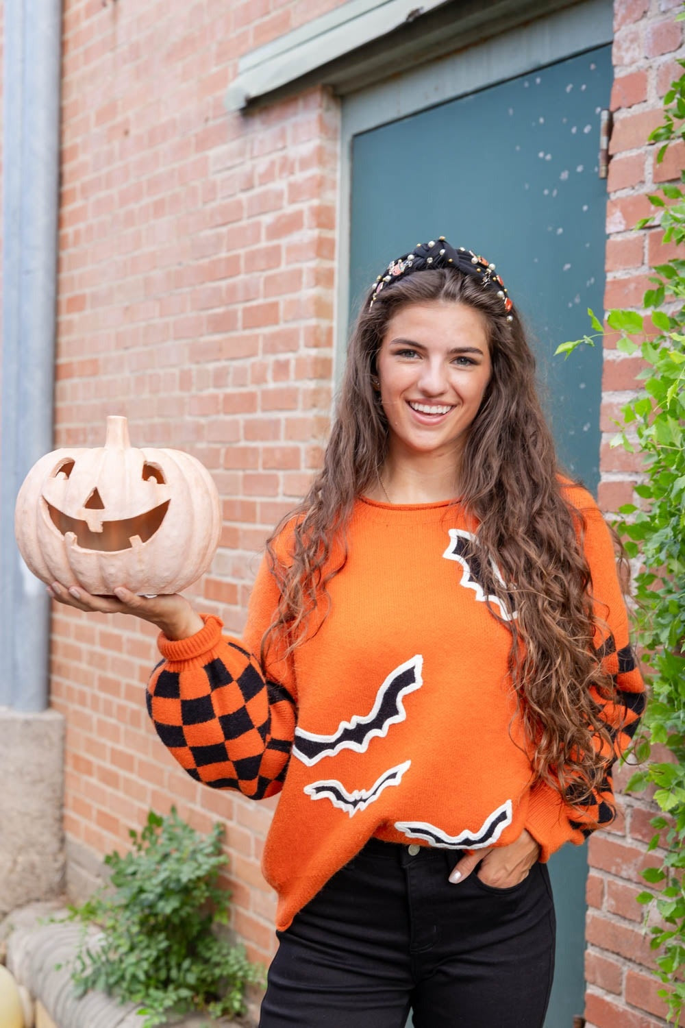 Oranje Halloween trui met geblokte mouwen en een pompoen