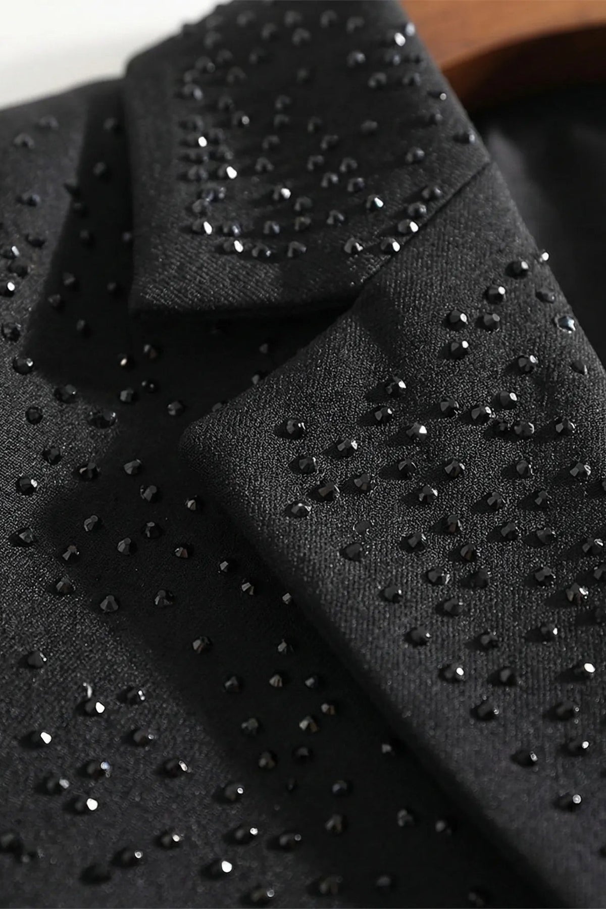 Close-up van de zwarte stof met strass steentjes op de revers van de blazer | Boutique Moda