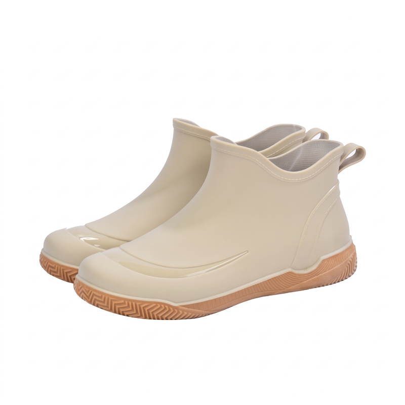 Een paar beige korte regenlaarzen met lichtbruine profielzool