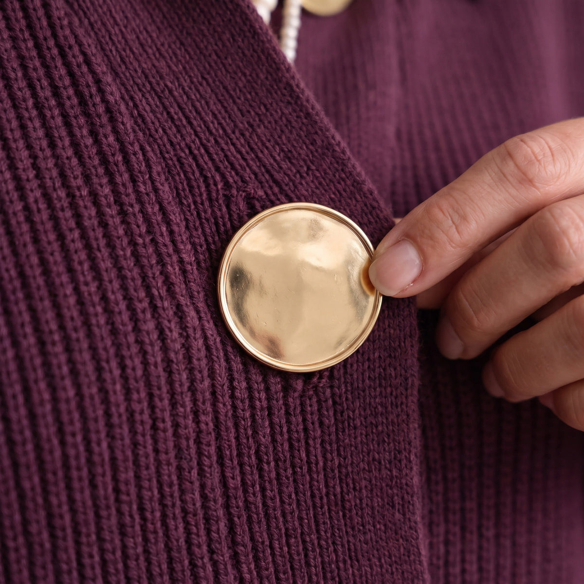 Paarse gebreide vest met grote gouden knoop, gedragen door persoon | Boutique Moda