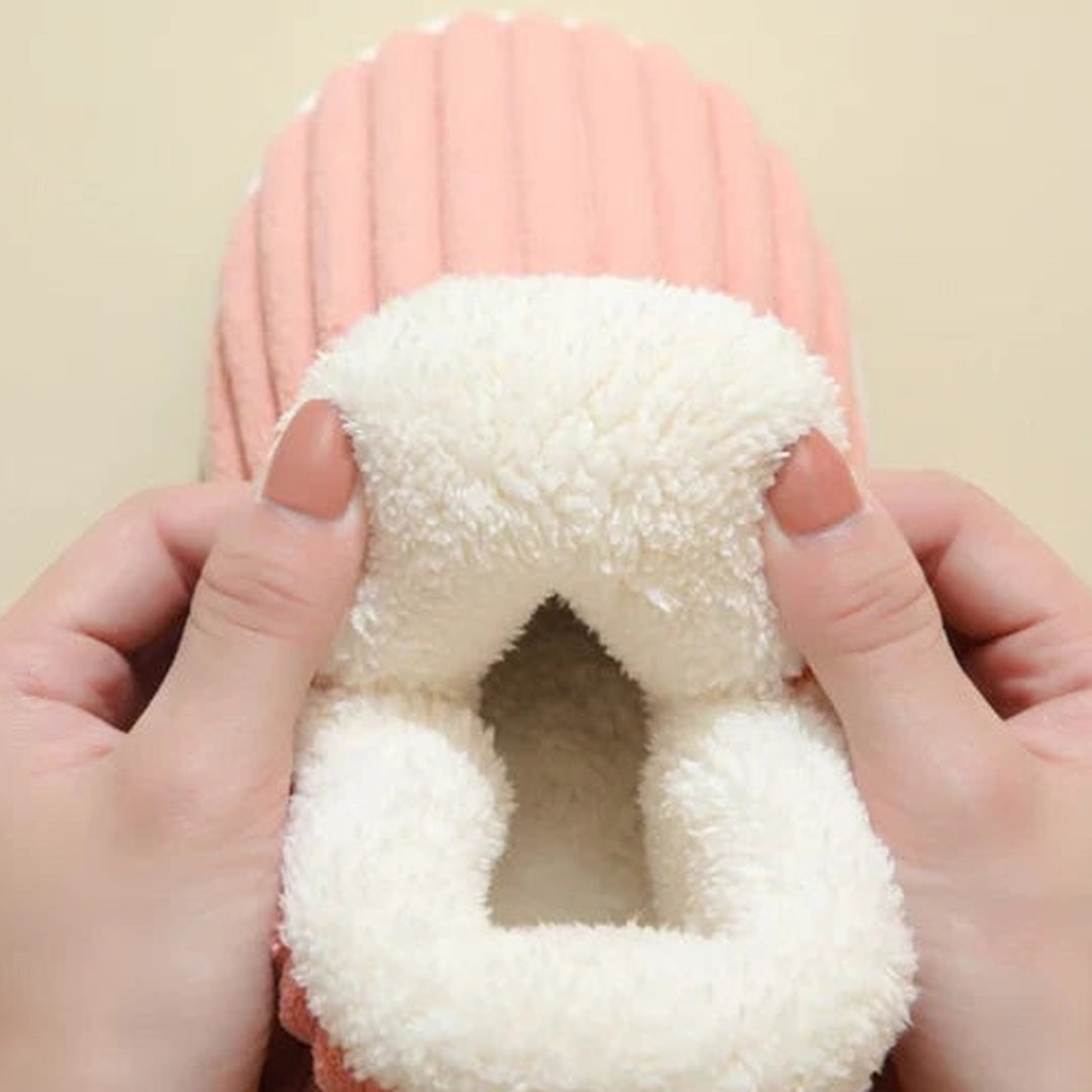 Roze pantoffel met zachte witte pluche voering, close-up met handen | Boutique Moda