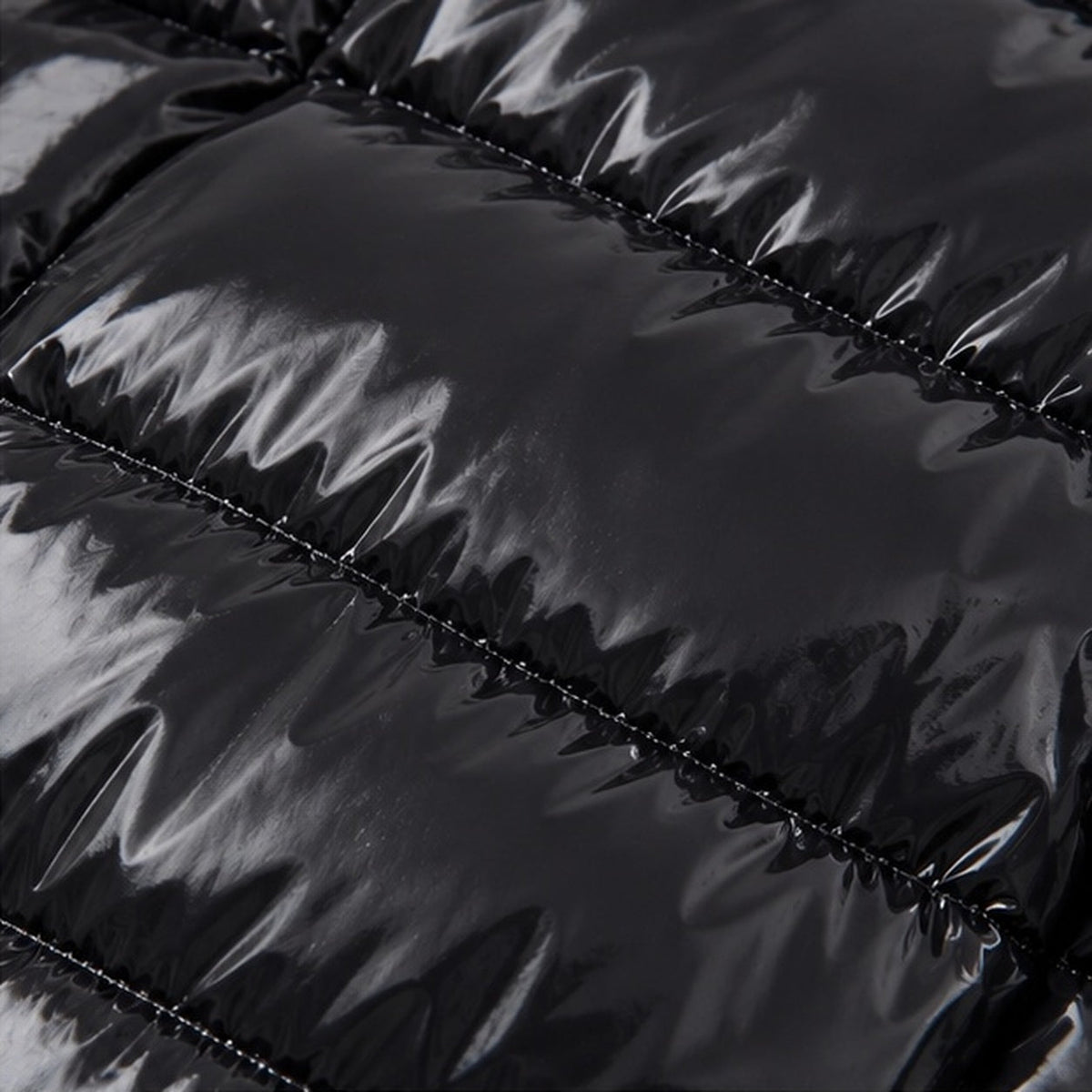 Close-up van glanzende zwarte gewatteerde winterjas met stiknaden, detailopname stof | Boutique Moda