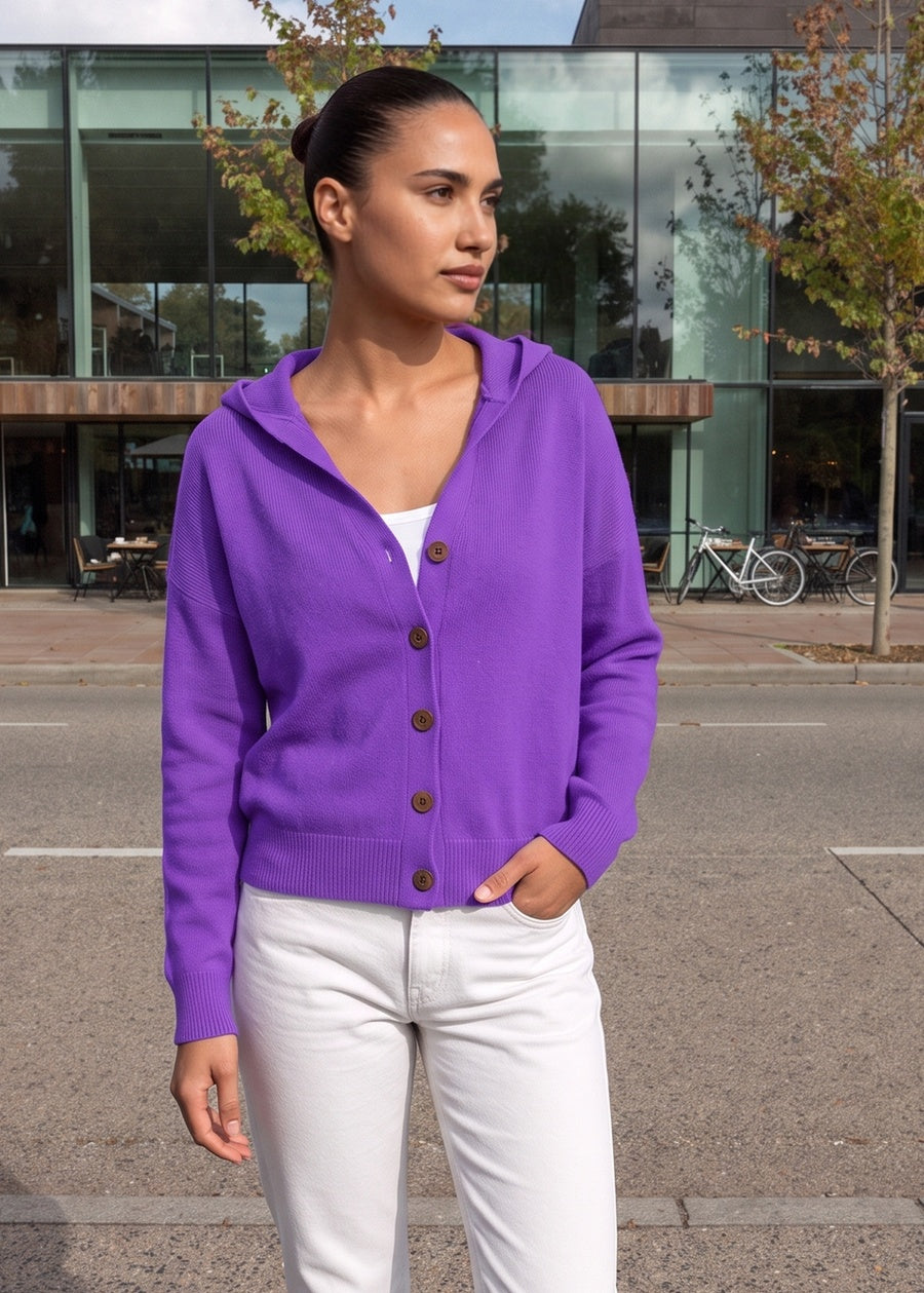 Vrouw in een paars capuchonvest met knoopsluiting in een straat in Rotterdam