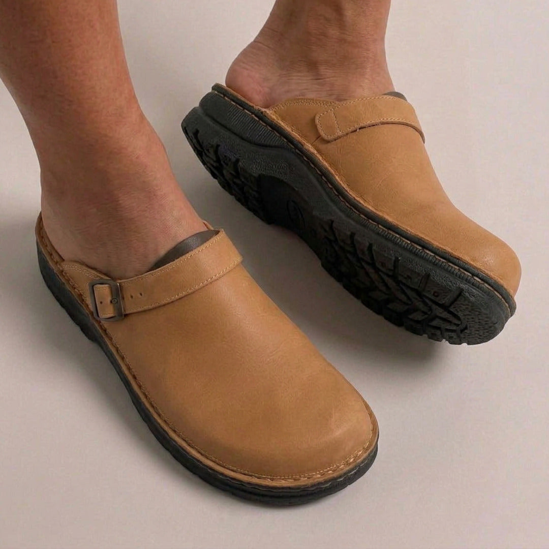 Beige vegan leren clogs met gesp en profielzool, gedragen aan blote voeten | Boutique Moda