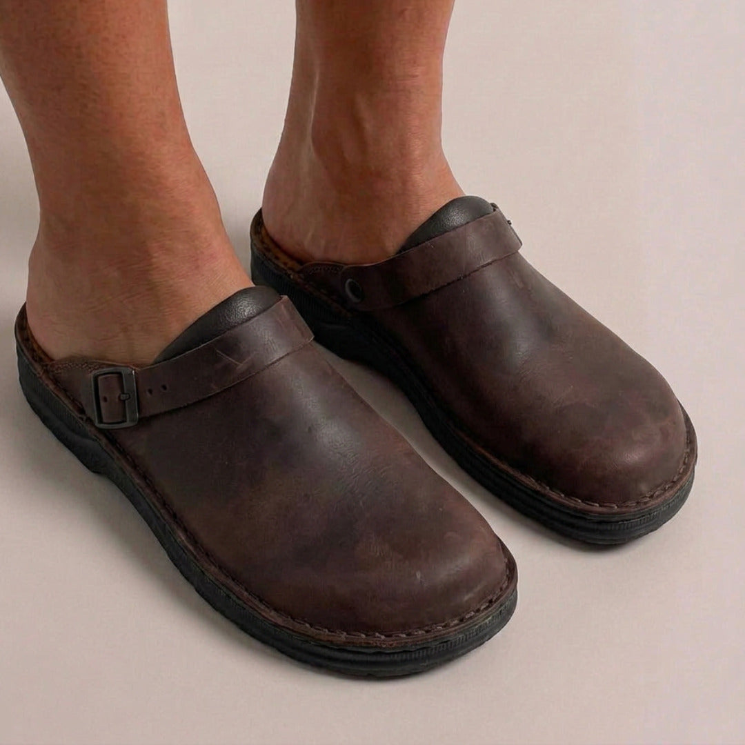 Bruine vegan leren clogs met gesp, gedragen aan blote voeten van persoon | Boutique Moda