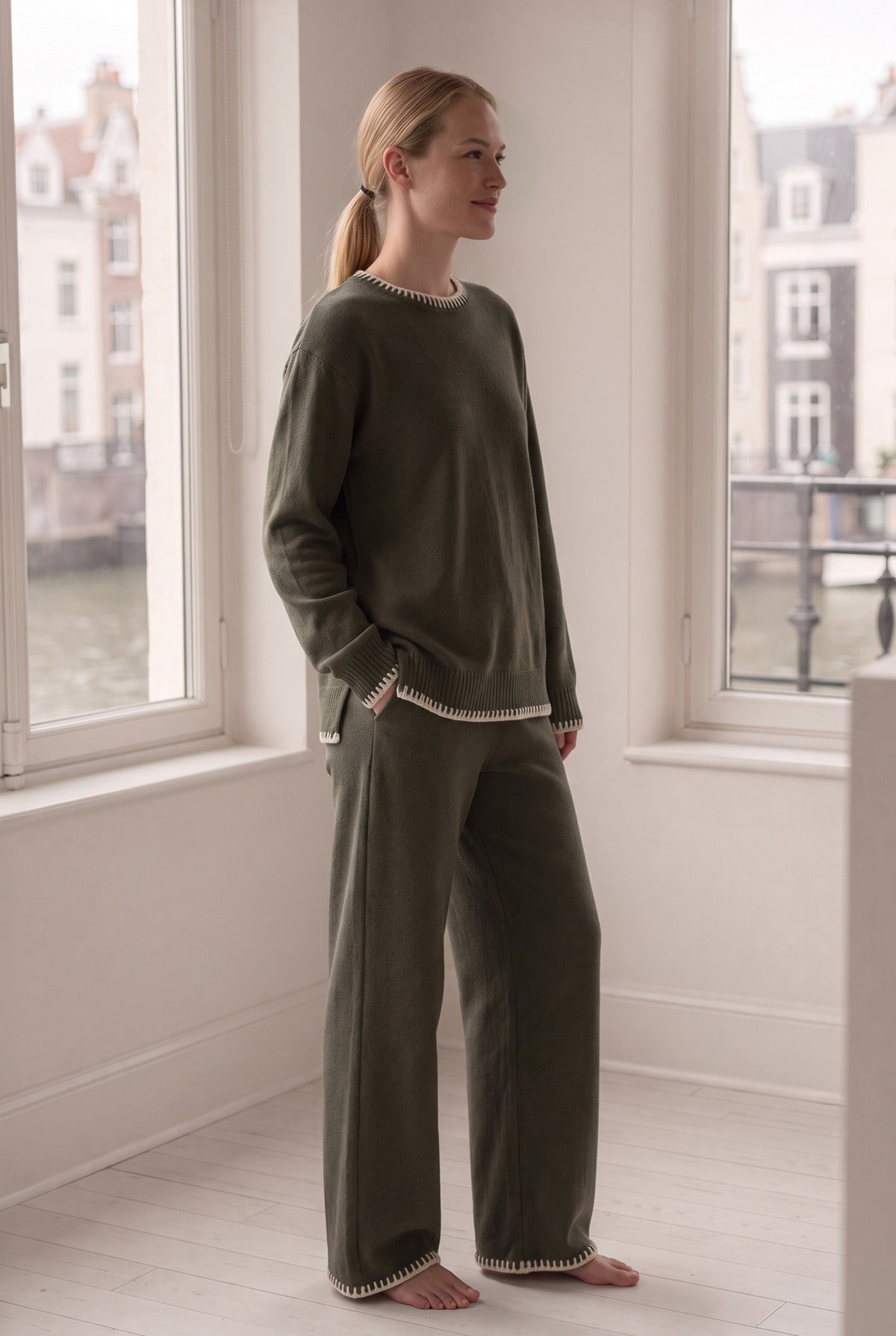 Vrouw in een comfy set met oversized trui en wijde broek in een Amsterdams appartement