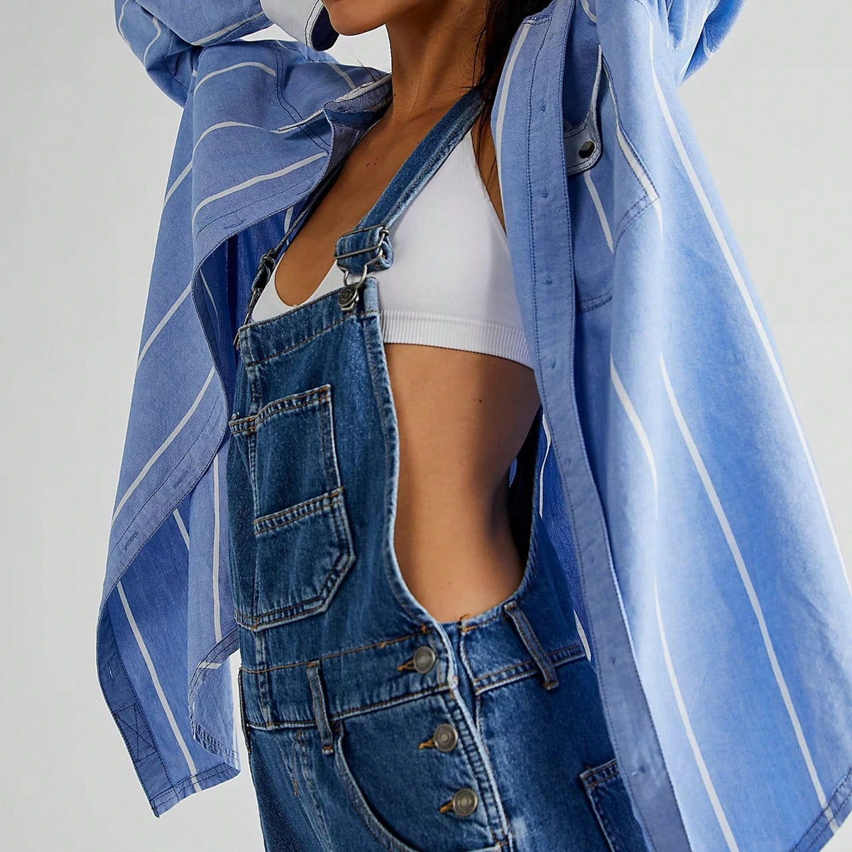 Blauwe denim tuinbroek gedragen met wit topje en gestreept overhemd | Boutique Moda