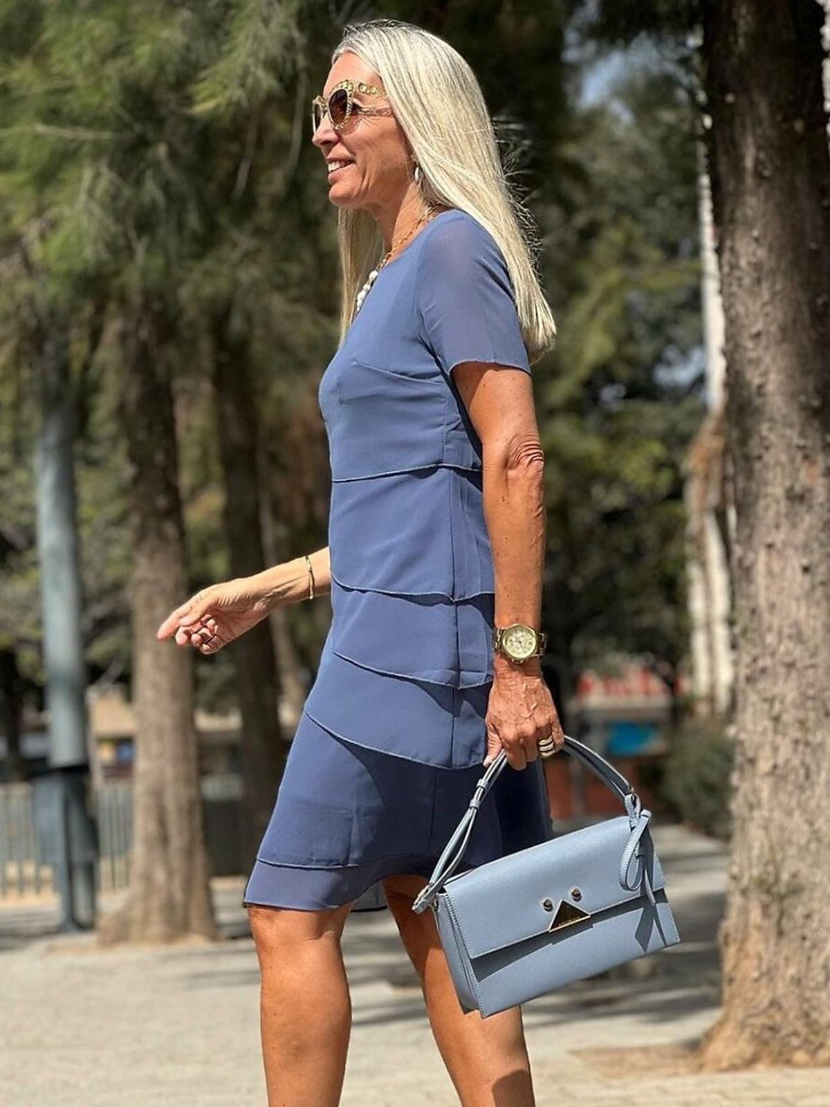 Blauwe gelaagde jurk met korte mouwen, gedragen door vrouw buiten | Boutique Moda