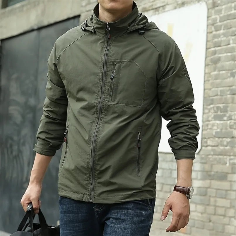 Legergroene outdoorjas met capuchon, gedragen door man met tas | Boutique Moda
