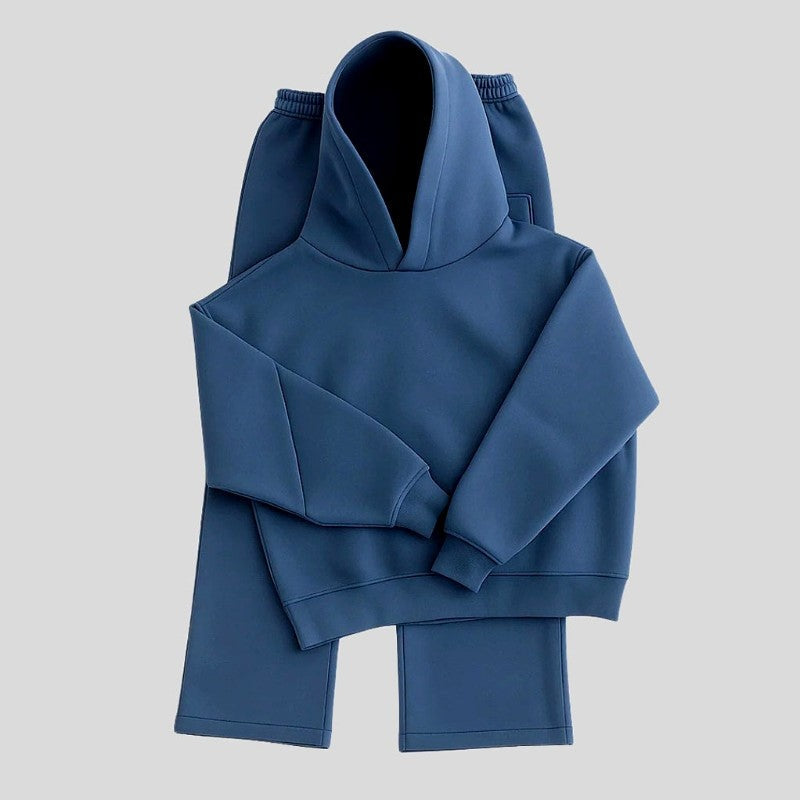 Blauwe hoodie en joggingbroek plat uitgestald op lichtgrijze achtergrond | Boutique Moda
