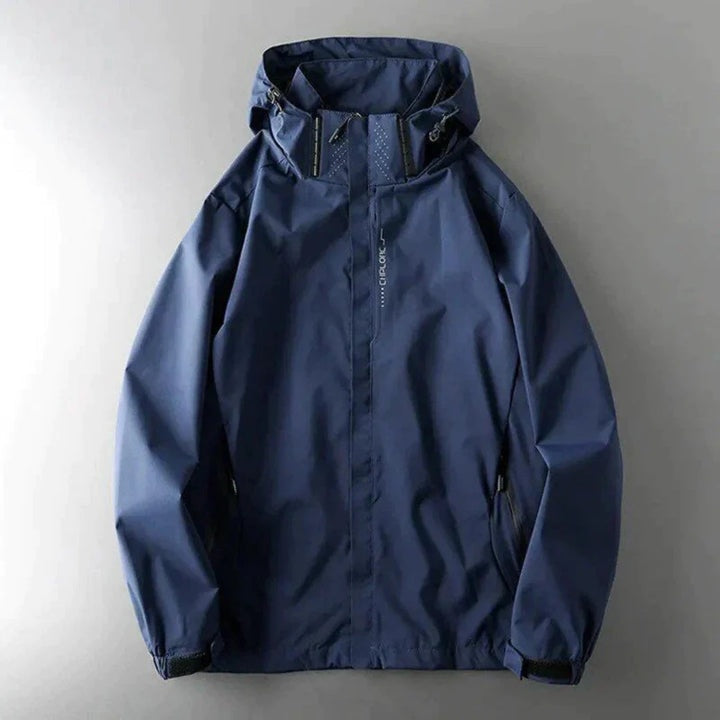Donkerblauwe windbreaker met capuchon en ritszakken, plat liggend gefotografeerd | Boutique Moda
