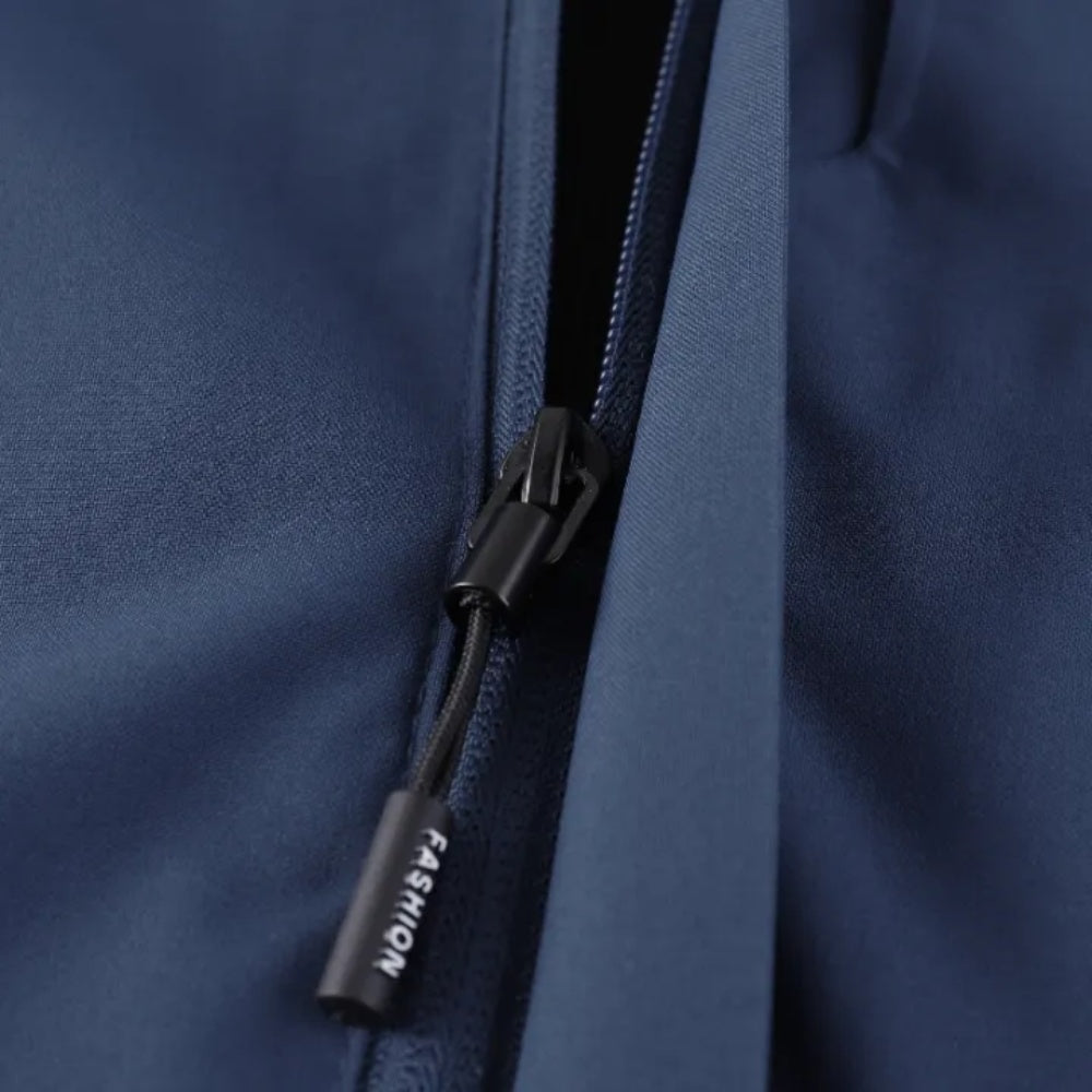 Close-up van marineblauwe ritssluiting met trekkoord op regenjack | Boutique Moda