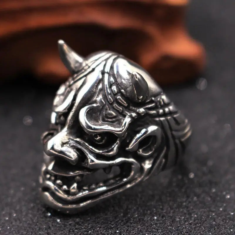 Zilverkleurige ring met gedetailleerd oni-demonenmasker en hoorn, los gefotografeerd | Boutique Moda