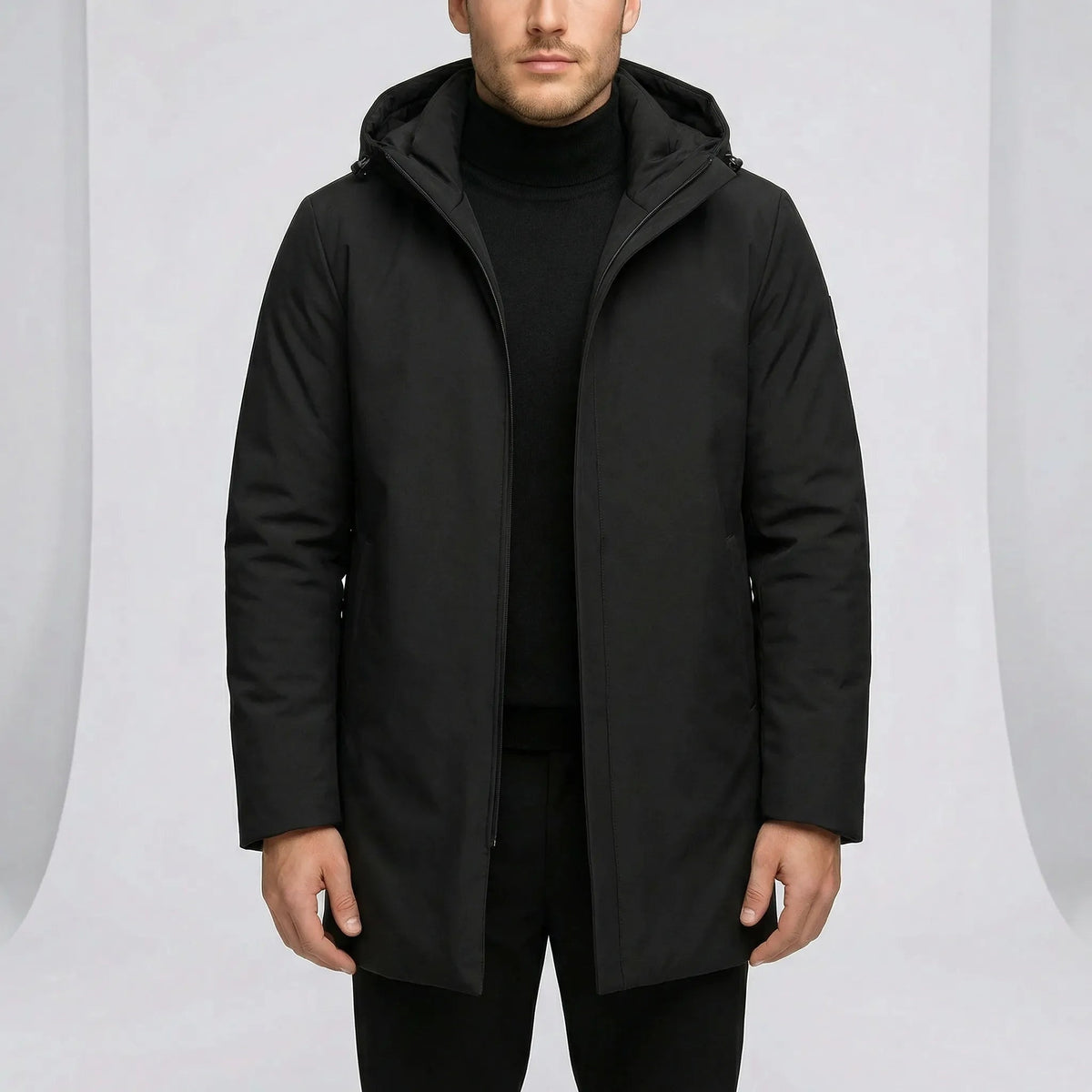 Zwarte regenjas met capuchon, gedragen door man, effen kleur | Boutique Moda