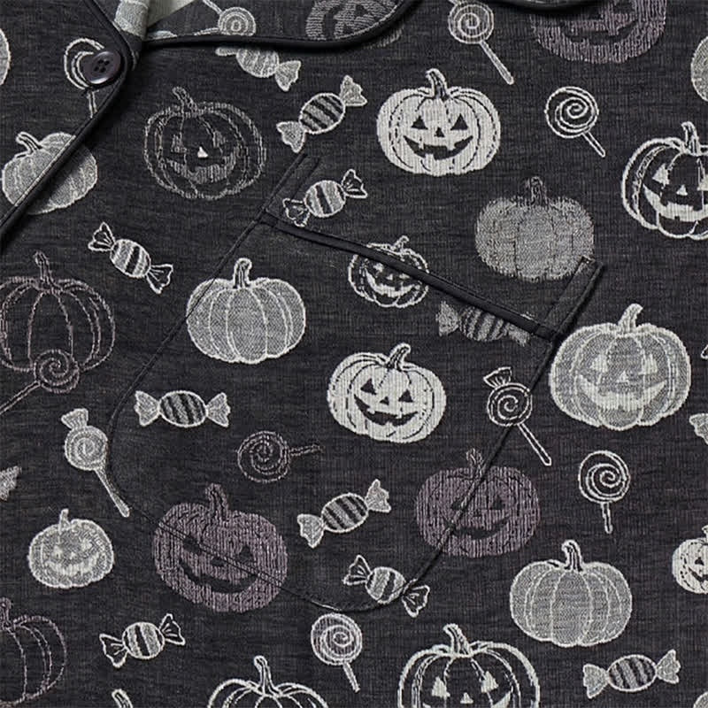 Zwarte pyjama met pompoenen en snoepprint, close-up van stof met zak | Boutique Moda