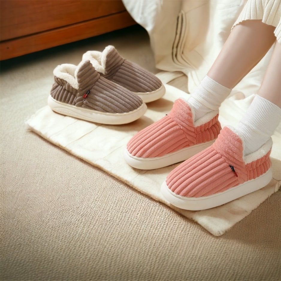 Roze ribstof pantoffel gedragen, bruine pantoffel ernaast op vloerkleed | Boutique Moda