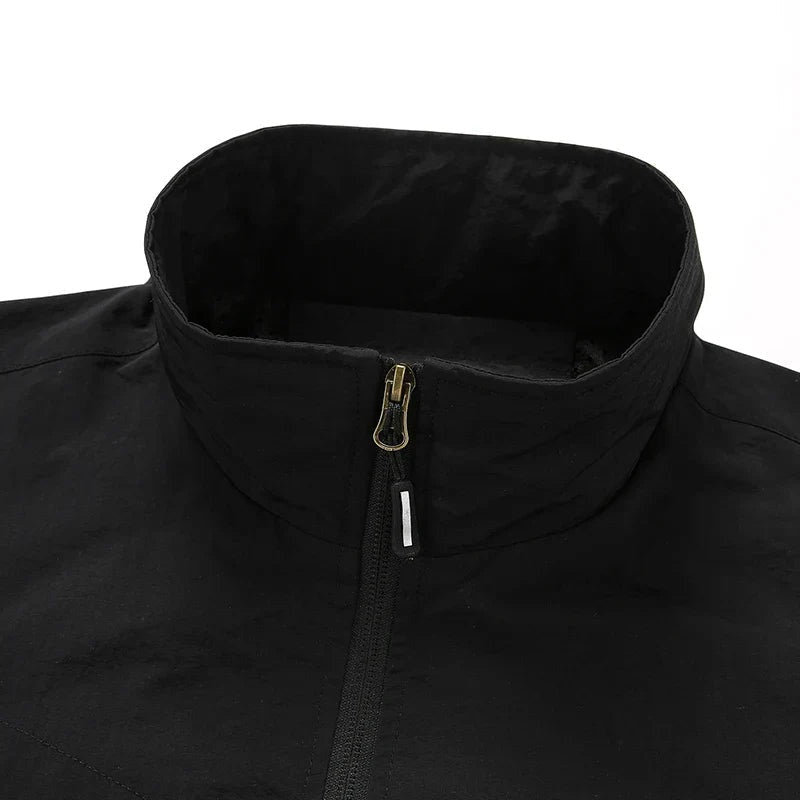 Zwarte jas met opstaande kraag en zilveren ritssluiting, close-up detail | Boutique Moda